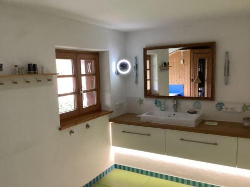 ein Bad mit einem Waschbecken und einem Spiegel in der Unterkunft Der Birkenhof-Ried in Pfaffing