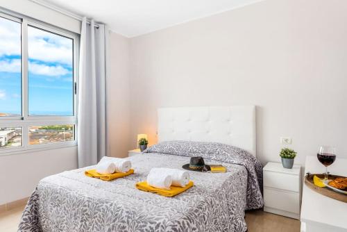 ein Schlafzimmer mit einem Bett mit Handtüchern und einem Fenster in der Unterkunft Apartamento Playa y Golf in San Miguel de Abona