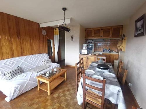 Cette chambre comprend une table, un lit et une cuisine. dans l'établissement Appartement avec vue T2 7pl 55m2 Orcières Merlette, à Orcières