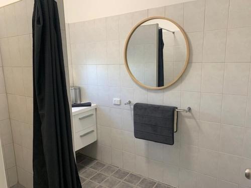 uma casa de banho com um espelho e um lavatório em draper em South Hedland