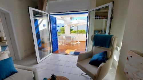 a living room with a couch and a sliding glass door at All Dreams Apartment - Urbanização Windmill in Albufeira