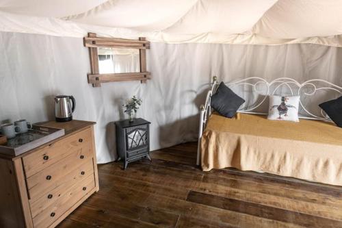 a bedroom with a bed with a canopy and a dresser at Glamping in Llanberis in Llanberis