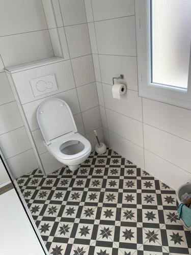 La salle de bains est pourvue de toilettes et de carrelage noir et blanc. dans l'établissement Vacances à la mer, à Banyuls-sur-Mer