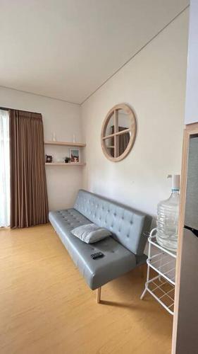 sala de estar con sofá azul y espejo en homestay Bumisarehat en Citeureup 1
