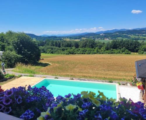 um jardim com piscina e flores em Ferienwohnung Martinschitz em Sankt Kanzian