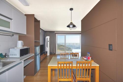 a kitchen with a table and chairs in a kitchen at Gyeongju Mauna Ocean Resort in Gyeongju