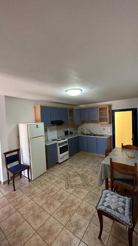 a kitchen with blue cabinets and a table and chairs at Kali’s casa in Karavomylos
