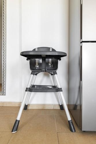 a black table on a stool next to a refrigerator at Splendide Appartement avec Piscine à Agadir in Agadir