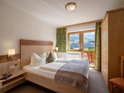 um quarto de hotel com uma cama e uma janela em Apart Magdalena em Hainzenberg