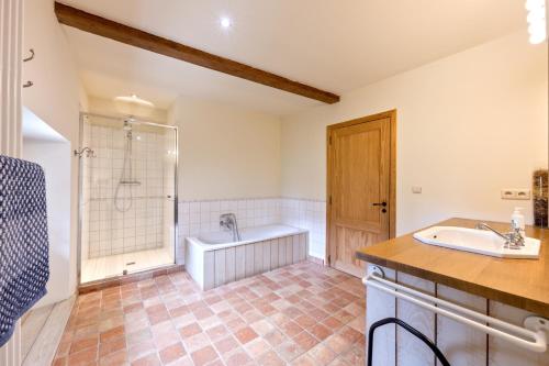 ein Bad mit einer Badewanne, einer Dusche und einem Waschbecken in der Unterkunft Le gîte de Froidefontaine in Havelange