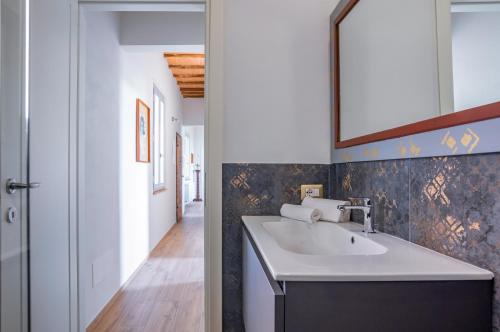 uma casa de banho com um lavatório e um espelho em Porta Romana Elegant House with Private Parking! em Siena