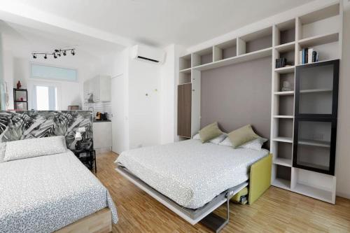 une chambre avec deux lits et une étagère dans l'établissement 55Birds - San Siro ed il centro a portata di mano, à Milan
