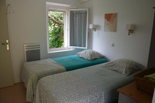 Duas camas num quarto com uma janela em Gîte Almanda - Calme & Nature - Mas Lou Castanea em Collobrières