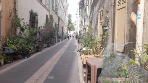 an empty alley with benches and potted plants at Le cosy in Marseille