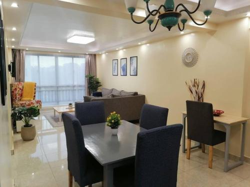 a living room with a table and chairs and a couch at Serene apartment in the suburbs in Nairobi