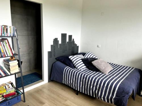 - une chambre avec un lit orné d'une fresque murale représentant la ville dans l'établissement La Maison de Famille, à Arles