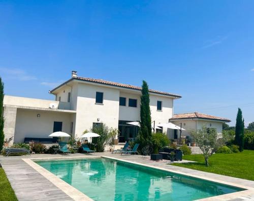 une maison avec une piscine devant une maison dans l'établissement La Maison de Famille, à Arles