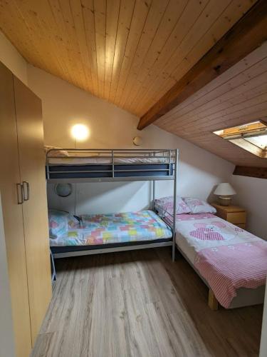Cette chambre comprend 2 lits superposés et un plafond en bois. dans l'établissement Village Océlandes, à Saint-Julien-en-Born