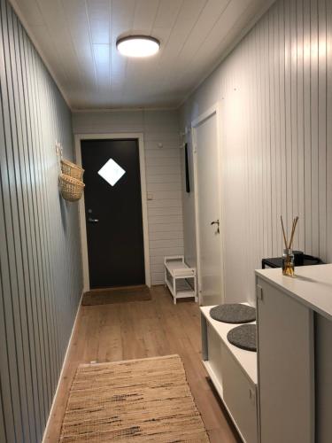 un corridoio con porta nera e una stanza con un tappeto di Modern apartment with an amazing seaview a Ballstad