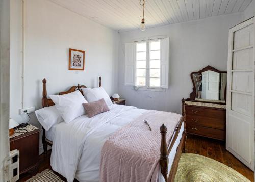 1 dormitorio con 1 cama blanca grande y espejo en Casona de la Ribeira Sacra en Pobra do Brollón