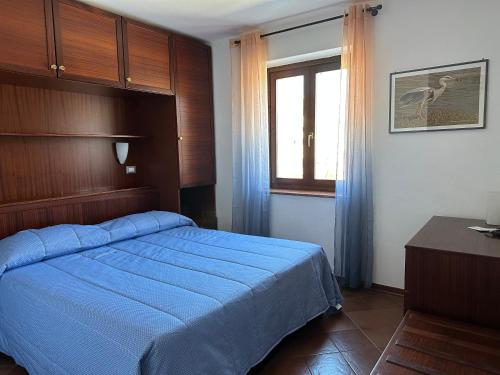 a bedroom with a blue bed and a window at Hotel Alla città di Trieste in Grado