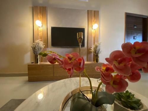 a vase with pink flowers in a living room at 3 Bed DD Luxury Apt SMCHS in Karachi