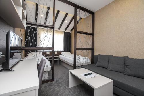 Atrijum Apartments and Rooms في كلادوفو: غرفة معيشة مع أريكة وسرير