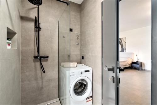 a bathroom with a washing machine and a shower at Valla Family Apartments and Rooms in Funtana