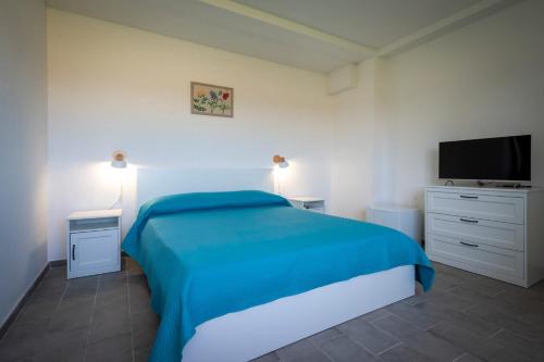 Schlafzimmer mit einem blauen Bett und einem Flachbild-TV in der Unterkunft Agriturismo Farfollíe in Pescia Romana