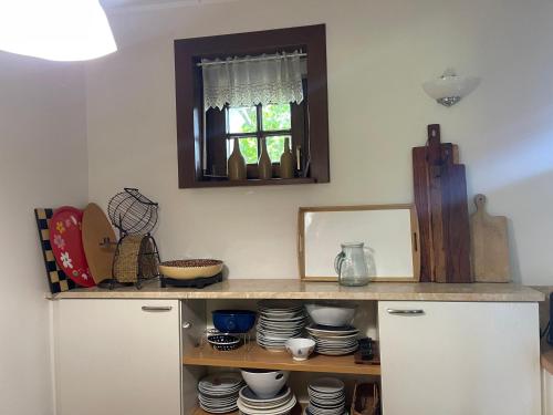 une cuisine avec une étagère, de la vaisselle et un miroir dans l'établissement Komfortowy dom w lesie, à Miedzichowo