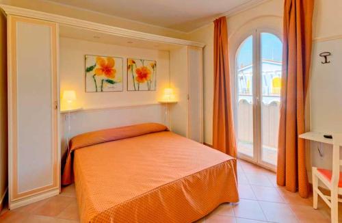 a bedroom with an orange bed and a window at La Piazzetta in Numana