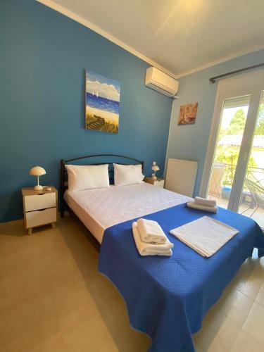 a bedroom with a bed and a blue wall at nikol_house in Alepou