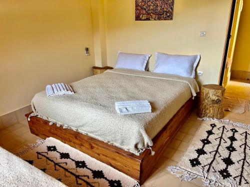 a bedroom with a wooden bed with blue pillows at Dar l'eau Vive in Bine el Ouidane