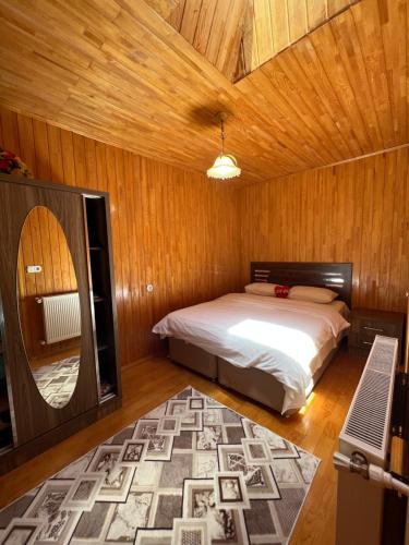 a bedroom with a bed and a wooden ceiling at Zeren Pansiyon in Uzungöl