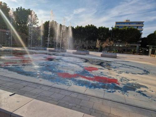 une fontaine dans un parc avec une piscine d'eau dans l'établissement Le National, à Sète