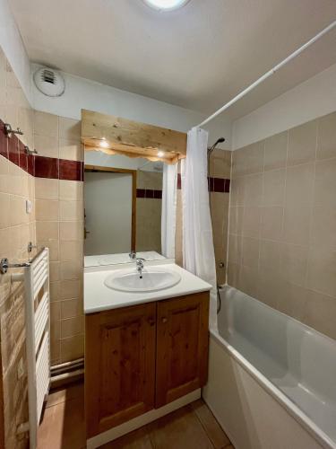 une salle de bain avec un lavabo et une baignoire dans l'établissement Appart 250m des pistes et parking couvert privatif, à Orcières