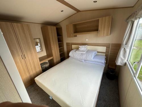 Habitación pequeña con cama en remolque en 27 Rickardos Holiday Lets 3-Bed Caravan near Mablethorpe, en Saltfleet