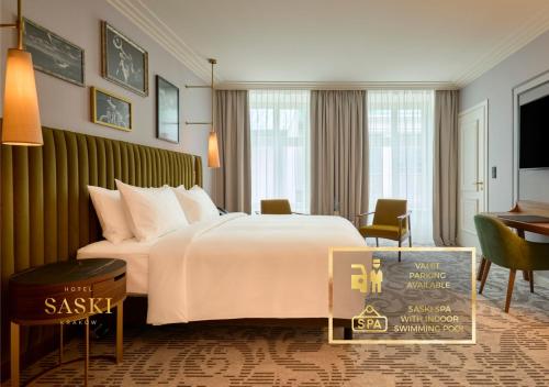 a hotel room with a large bed and a desk at Hotel Saski Krakow Curio Collection by Hilton in Kraków