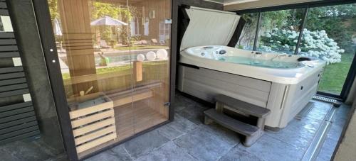 een badkamer met een bad, een wastafel en een raam bij Demeure Les Aiglons, Chambres d'hôtes & Spa in Fontainebleau