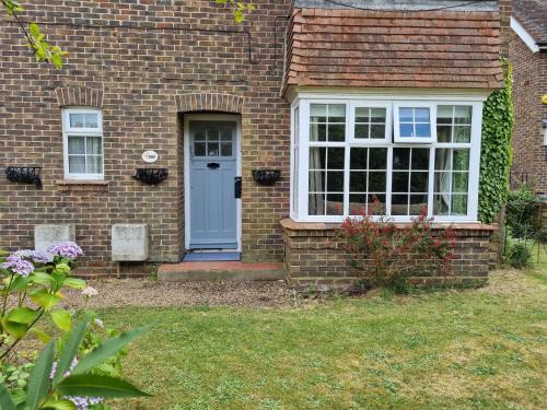 uma casa de tijolos com uma porta azul e uma janela em Grace Lodge em Southbourne
