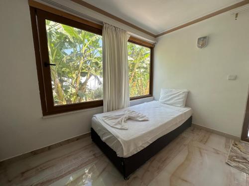ein Schlafzimmer mit einem Bett und einem großen Fenster in der Unterkunft Kiriş Garden Hotel in Kemer