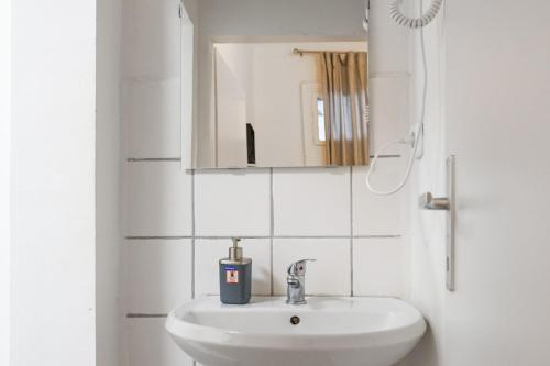 biała łazienka z umywalką i lustrem w obiekcie Affordable 2BR Apt- Connected to the whole city w Wiedniu