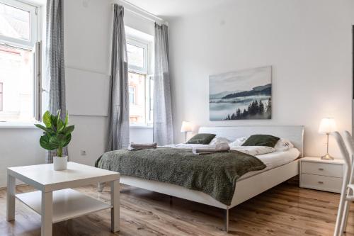 biała sypialnia z dużym łóżkiem i oknami w obiekcie Affordable 2BR Apt- Connected to the whole city w Wiedniu