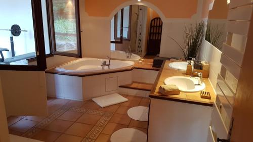 une salle de bain avec deux lavabos, une baignoire et un miroir dans l'établissement Villa en Provence, à Flayosc