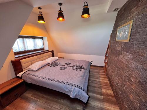 um quarto com uma cama, uma janela e luzes em Śtadraj em Bukowina Tatrzańska