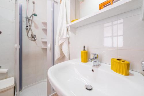 ein weißes Bad mit einem Waschbecken und einer Dusche in der Unterkunft Villetta Sant'andrea in Quartu SantʼElena