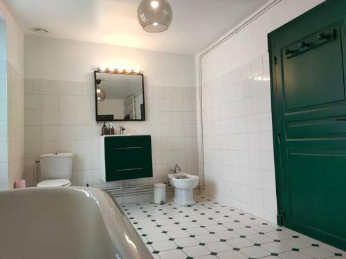 a bathroom with a tub and a toilet and a mirror at Ancienne ferme Chessy in Chessy