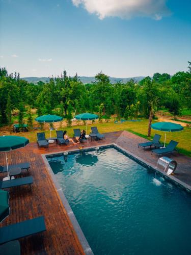 a swimming pool with lounge chairs and umbrellas at Palm Bungalov Hotel in Kartepe