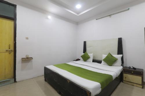 a bedroom with a large bed with green and white sheets at Hotel Dayal in Lucknow