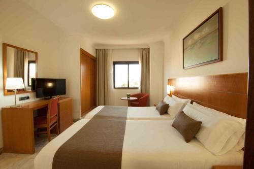 a hotel room with a large bed and a desk at Hotel Principe Paz in Santa Cruz de Tenerife